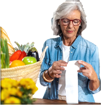 Woman looking at her grocery receipt with a basket of fruit next to her. 